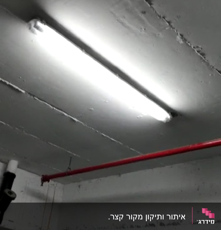 תאורת פלורסנט מותקנת על תקרה עם צינור אדום